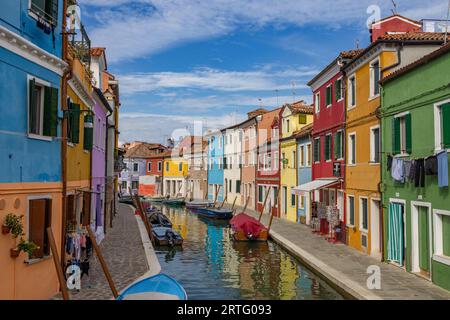 Burano, Italien - 9. August 2023; Blick auf farbenfrohe venezianische Häuser entlang des Kanals auf den Inseln Burano in Venedig - Ein fantastisches Reiseziel Stockfoto