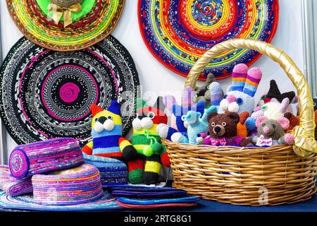 Buntes gestricktes, handgemachtes Kinderspielzeug im Korb. Selbstgemachte Handarbeiten und Stickereien. Stockfoto