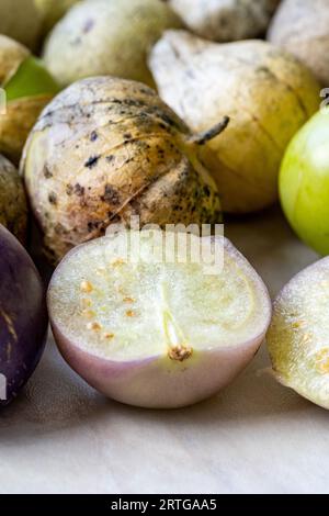 Tomatillos, grüne Tomaten, mit Salsa verde, grüner Sauce, in einer Molcajete, traditioneller mexikanischer Mörser. Organische Lebensmittel. Stockfoto