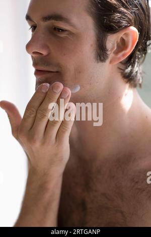 Nahaufnahme des Jünglings Feuchtigkeitscreme auftragen Stockfoto