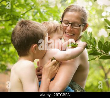 Familie steht in einem Garten umarmen Stockfoto