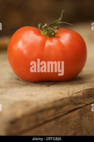 Nahaufnahme einer Rotwein-Tomate auf einer Holzoberfläche Stockfoto