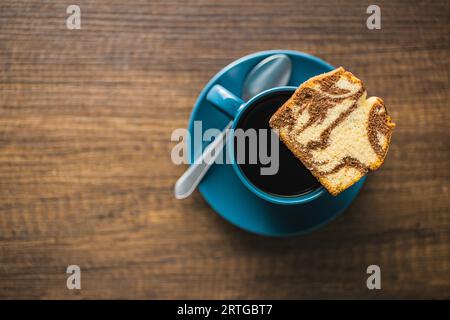 Marmor-Biskuitkuchen und Kaffeetasse. Der Kuchen mit Kakao- und Vanillegeschmack. Draufsicht. Stockfoto