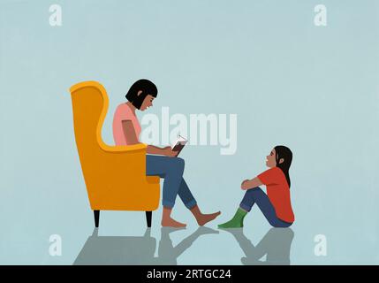 Mutter im Sessel liest Buch an Tochter zu Hause Stockfoto