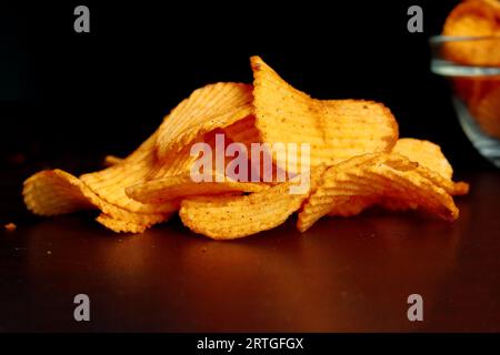 Kartoffelchips auf einem Holztisch, Kartoffelchips auf einem hölzernen Hintergrund, Stockfoto