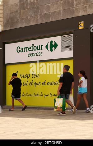 Viladecans, Spanien - 13. September 2023: Carrefour Express-Werbeschild im Freien mit vorbeiziehenden Personen. Stockfoto