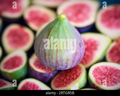 Von oben Nahaufnahme vieler exotischer reifer, ungeschälter Früchte mit grüner und violetter Rinde Stockfoto