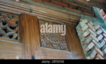 Antike Kammer aus Holz, befestigt an einer Ziegelmauer. Stockfoto