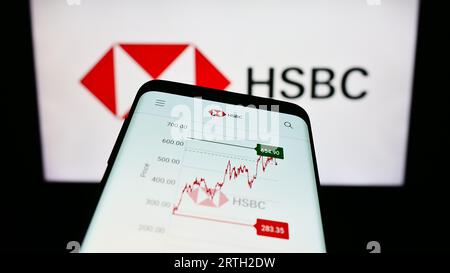 Mobiltelefon mit Webseite des Finanzdienstleistungsunternehmens HSBC Holdings plc auf dem Bildschirm vor dem Firmenlogo. Konzentrieren Sie sich auf die obere linke Ecke des Telefondisplays. Stockfoto