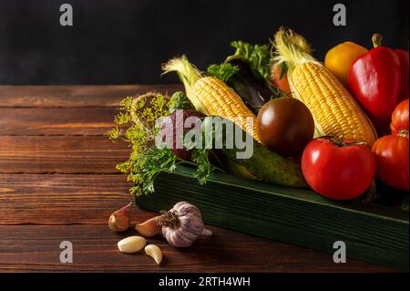 Gemüsesorten in Holzschale. Gemüsesatz zur Konservierung auf dunklem Hintergrund mit Kopierraum Stockfoto