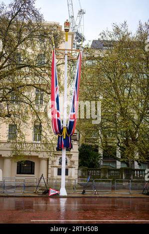 LONDON - 24. April 2023: Flaggen auf der Mall markieren die Vorbereitungen für die Krönung von König Charles, auch bei nassem Wetter. Stockfoto