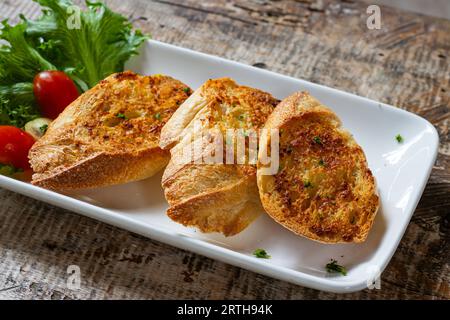 Frisches knuspriges Knoblauchbrot auf weißem Teller Stockfoto