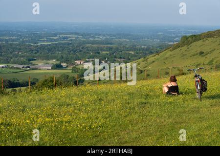 Eine Frau, die die Aussicht auf den South Downs National Park, Brighton, East Sussex, England, Großbritannien bewundert Stockfoto