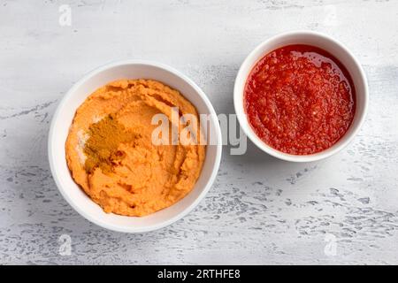 Zutaten für hausgemachte Linsenpfannkuchen: Frische Tomatensauce mit Gewürzen, gemahlenen roten Linsen und Gewürzen - Kurkuma, Paprika, Salz auf hellgrauem Hintergrund Stockfoto