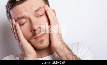 Nahaufnahme eines Mannes mit Kopfschmerzen Stockfoto