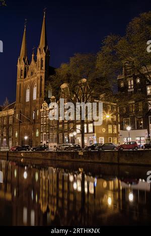 Nachtaufnahme der Kirche de Krijtberg in Amsterdam, Niederlande im Frühjahr Stockfoto