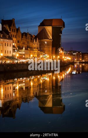 Altstadt von Danzig in Polen durch die Nacht, den Kran mittelalterlichen Wahrzeichen und Symbol für eine alte Hafenstadt mit Wasserreflexion über Mottlau Stockfoto