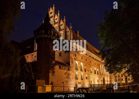 Schloss Malbork in Polen, mittlere Burg bei Nacht beleuchtet, mittelalterliche Festung des Deutschen Ritterordens aus dem 13. Jahrhundert, UNESCO-Weltkulturerbe Stockfoto