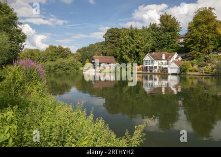 Blick auf Häuser und Bootshäuser am Flussufer mit Reflexion entlang der Themse, Goring-on-Thames, Oxfordshire, England, Vereinigtes Königreich, Europa Stockfoto