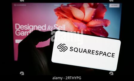 Person, die ein Smartphone mit dem Logo der US-Website-Building-Firma Squarespace Inc. Auf dem Bildschirm vor der Webseite hält. Konzentrieren Sie sich auf das Display des Telefons. Stockfoto