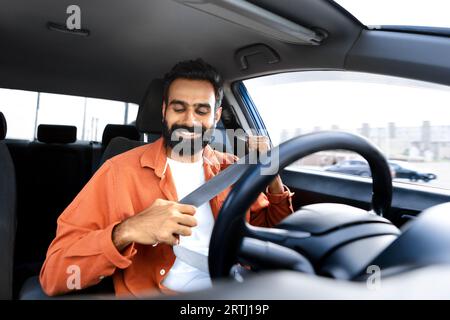 Indischer Fahrer, Der Den Sicherheitsgurt Für Car Trip Anlegt Stockfoto