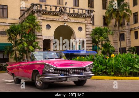 Havanna, Kuba am 13. Januar 2016: Ein roter Oldtimer fährt vor dem berüchtigten Havanas Hotel National, das den Charme der Goldenen 20er Jahre bewahrt Stockfoto