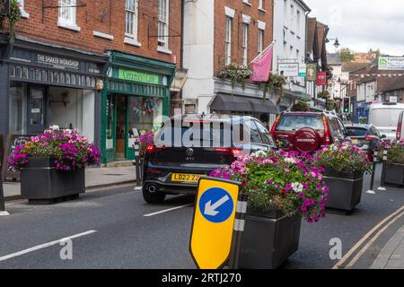 Verkehrsberuhigung, Pflanzgefäße mit Blumen auf der Straße, um sie zu schmälern und langsamer Verkehr, Farnham Stadtzentrum, Surrey, England, Großbritannien Stockfoto