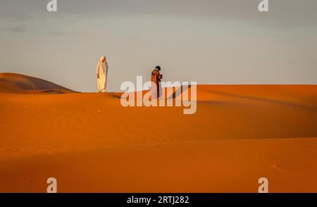 Merzouga, Marokko am 24. Februar 2018: Zwei Berber wandern in der Sahara, Merzouga, Marokko Stockfoto