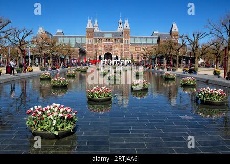 Tulpendekorationen spiegeln sich im Frühling im Brunnen vor dem Rijksmuseum in Amsterdam, Niederlande. Bunte Tulpen spiegeln sich in einem Teich wider Stockfoto