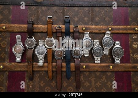 Das klassische Omega Speedmaster Shooting auf einer alten, genieteten Louis Vuitton Reisetasche mit dem kultigen LV-Muster. Stockfoto