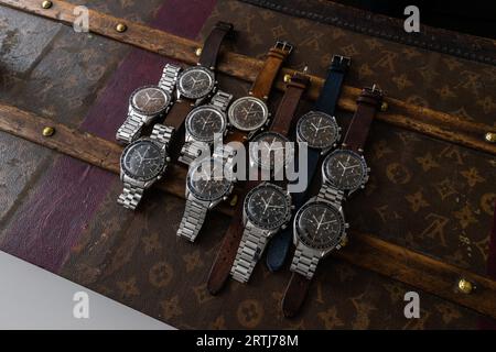 Das klassische Omega Speedmaster Shooting auf einer alten, genieteten Louis Vuitton Reisetasche mit dem kultigen LV-Muster. Stockfoto