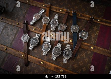 Das klassische Omega Speedmaster Shooting auf einer alten, genieteten Louis Vuitton Reisetasche mit dem kultigen LV-Muster. Stockfoto