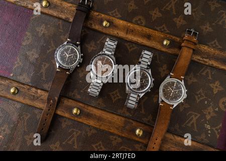 Das klassische Omega Speedmaster Shooting auf einer alten, genieteten Louis Vuitton Reisetasche mit dem kultigen LV-Muster. Stockfoto