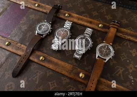 Das klassische Omega Speedmaster Shooting auf einer alten, genieteten Louis Vuitton Reisetasche mit dem kultigen LV-Muster. Stockfoto