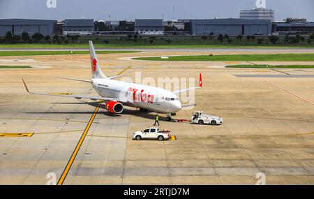 Flugzeuge werden durch Flugzeugschlepper auf Rollweg zurückgedrückt, eines in Bodenabfertigungsdiensten. Stockfoto