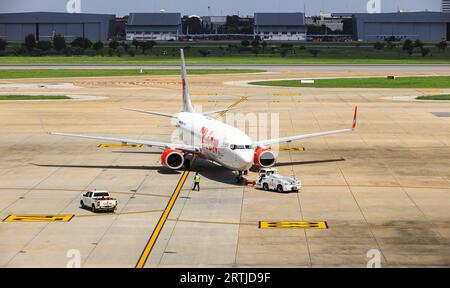 Flugzeuge werden durch Flugzeugschlepper auf Rollweg zurückgedrückt, eines in Bodenabfertigungsdiensten. Stockfoto