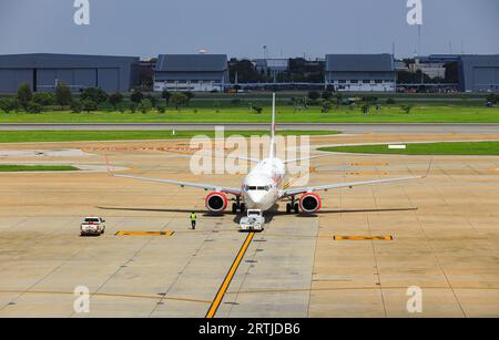 Flugzeuge werden durch Flugzeugschlepper auf Rollweg zurückgedrückt, eines in Bodenabfertigungsdiensten. Stockfoto