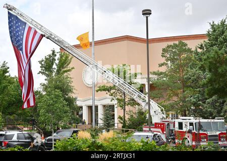 Santa Fe, Usa. September 2023. Eine große amerikanische Flagge wird an einer Feuerwehrleiter zu Ehren des ehemaligen New Mexico-Gouverneurs Bill Richardson gehängt, während seine mit einer Flagge bedeckte Schatulle im Bundesstaat Santa Fe in der Rotunde des New Mexico State Capitol Building am 13. September 2023 in Santa Fe, New Mexico, liegt. Richardson, der als 30. Gouverneur von New Mexico diente, starb am 1. September 2023. (Foto: Sam Wasson/SIPA USA) Credit: SIPA USA/Alamy Live News Stockfoto