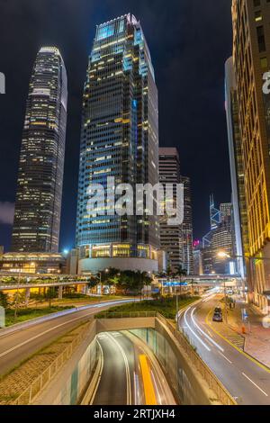 Connaught Road zentraler Überflug in Hongkong bei Nacht am Fuße des One International Finance Centre. Mit leichten Streifen beweglicher Autos Stockfoto