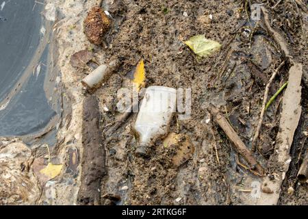 Müll und Verschmutzung sammeln sich an einem Dock in einem Fluss Stockfoto