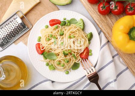 Teller mit leckeren Pasta primavera, Zutaten und Gabel auf dem Tisch, flach gelegt Stockfoto