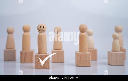 Concept Business und HR für die Führung und den Teamleiter unterscheidet sich eine Holzpuppe und hebt sich von der Gruppe ab. Stockfoto