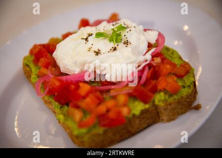 Avocado-Toast mit pochiertem Ei und Gemüse Stockfoto