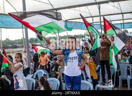 Gaza, Palästina. September 2023. Ein palästinensisches Mädchen hisst während der Demonstration entlang der Grenze zwischen Israel und Gaza die palästinensische Flagge und prangert die israelische Belagerung des Gazastreifens an. (Foto: Mahmoud Issa/SOPA Images/SIPA USA) Credit: SIPA USA/Alamy Live News Stockfoto