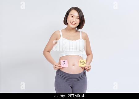 Schwanger mit einem Fragezeichen auf dem Post-it-Aufkleber auf dem Bauch Stockfoto