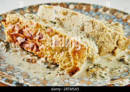 Hühnerterrine mit Paprika, Zwiebeln und Kräutern auf dem Teller Stockfoto
