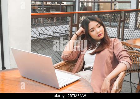 Porträt einer verschlafenen attraktiven asiatischen Freiberuflerin, die sich nach Überlastung gestern Abend müde fühlt Stockfoto