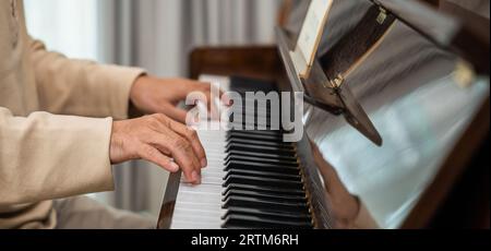 Asiatischer Rentner lernte zu Hause Klavier zu spielen Stockfoto