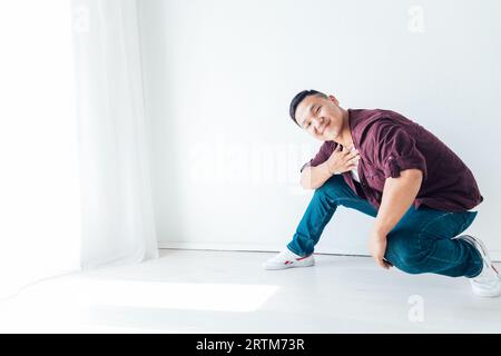 Ein Mann sitzt im weißen Tanzstudio und Tänzer Hip Hop Stockfoto