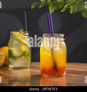 Frisch zubereitete Limonade und Früchte mit Geleebugeln auf Holztisch kühlen Stockfoto